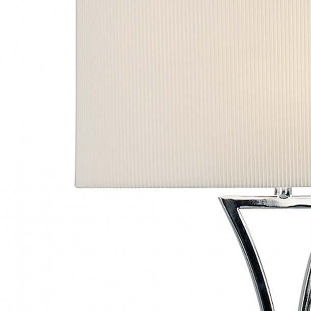 De líneas escultóricas y acabada en cromo pulido, la lampara Oporto se acompaña de una pantalla con ligeros pliegues en crema.