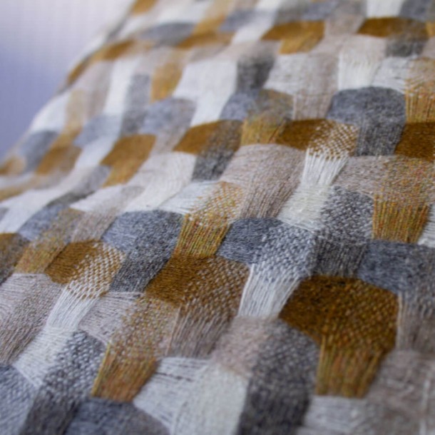 Precioso cojín de lana, reversible, con diseño Tweed ocre ribeteado.