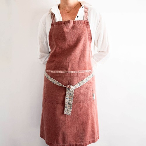Daniela red apron, Laura Ashley. Composition: 40% Cotton, 30% Linen, 30% Polyester. Supports machine washing up to 40º C.